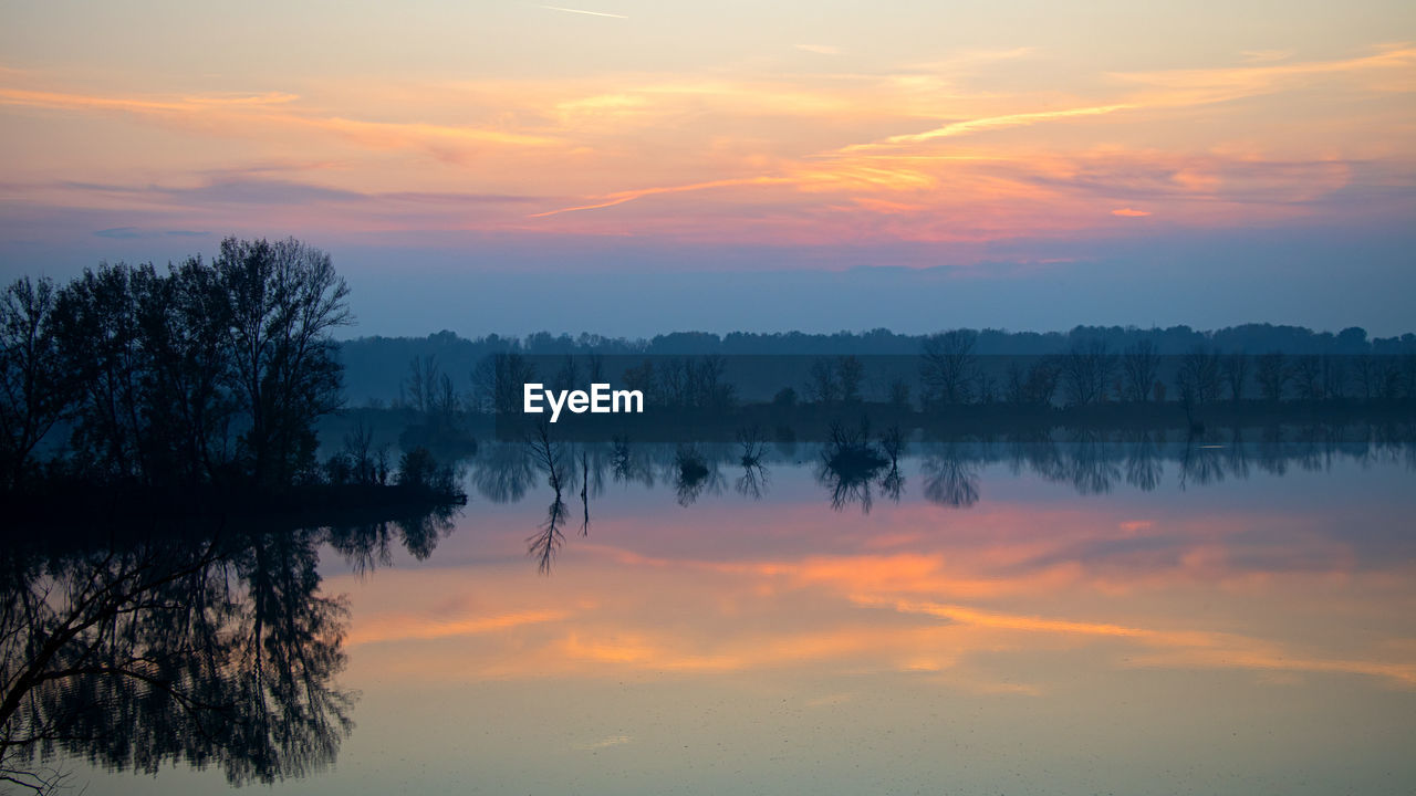 Scenic view of lake against romantic sky at sunset