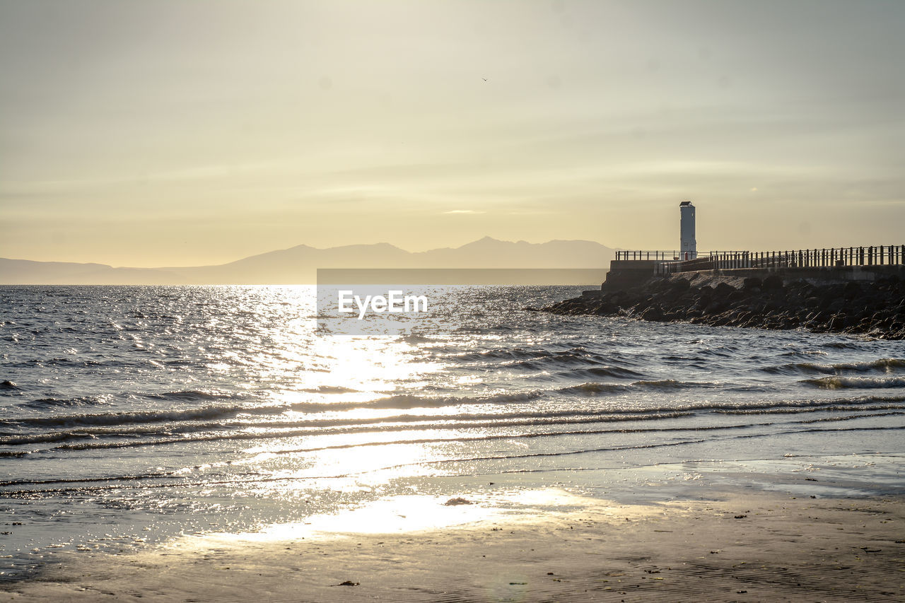 SCENIC VIEW OF BAY AGAINST SKY DURING SUNSET