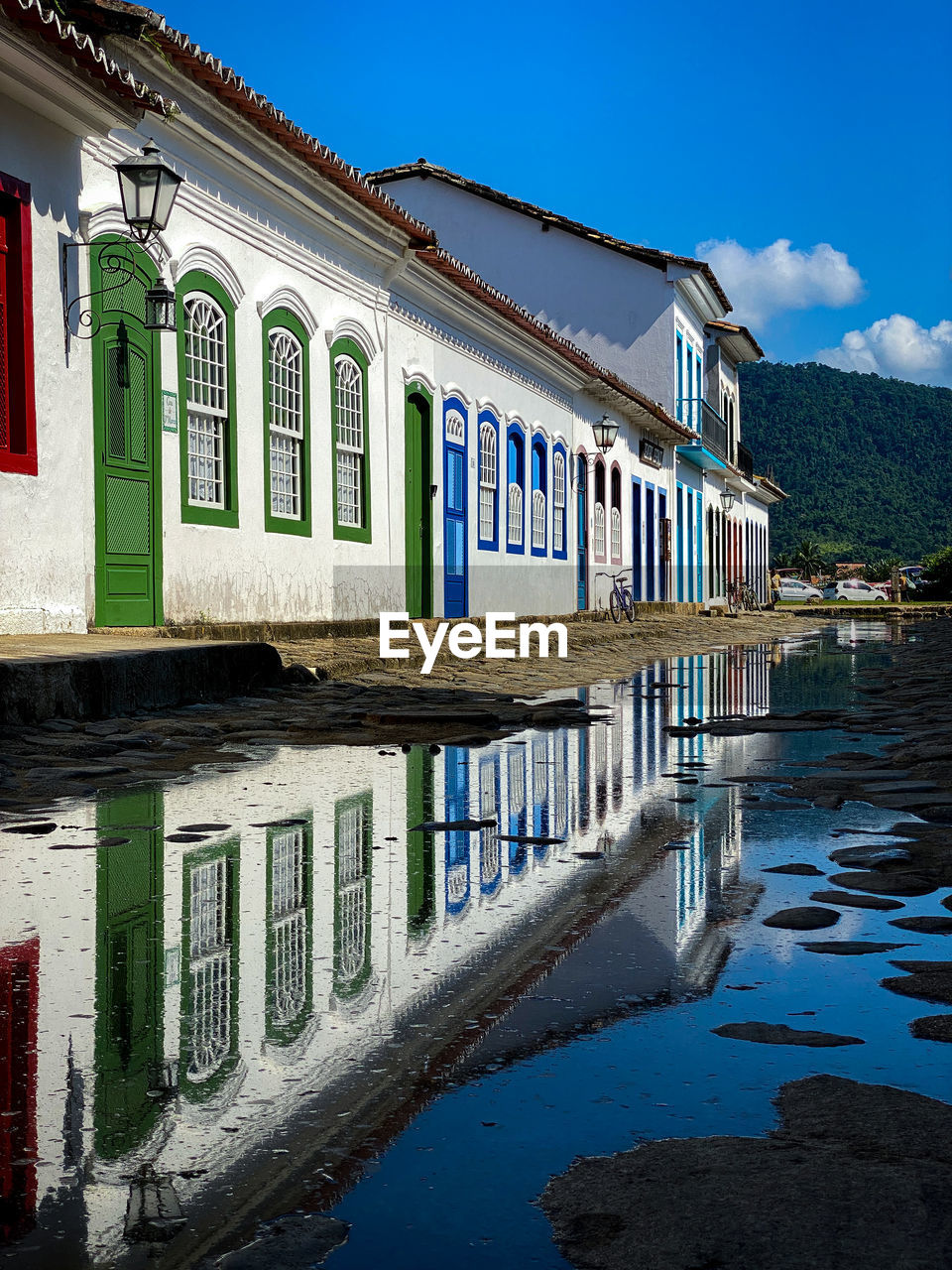 Buildings by canal against blue sky