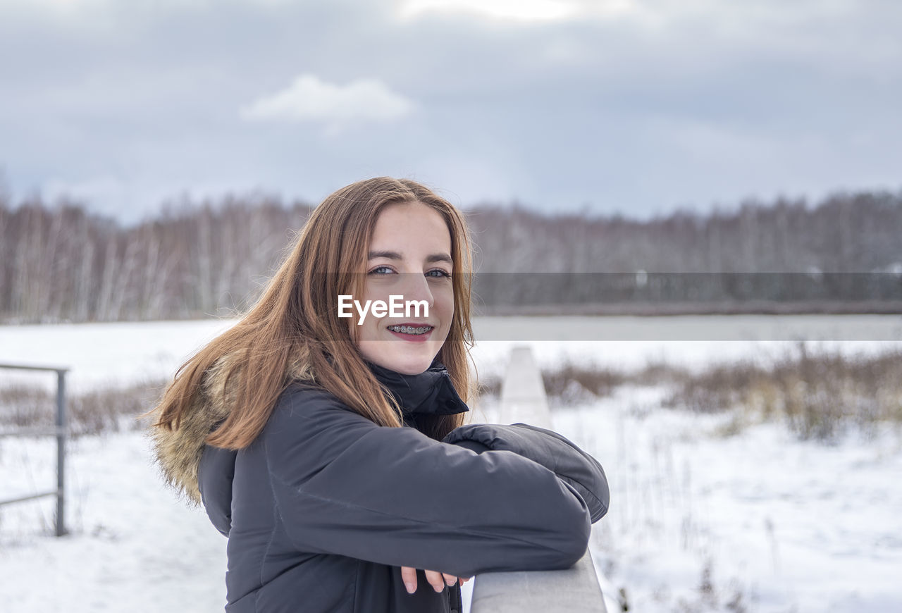 Portrait of smiling girl on snow covered land