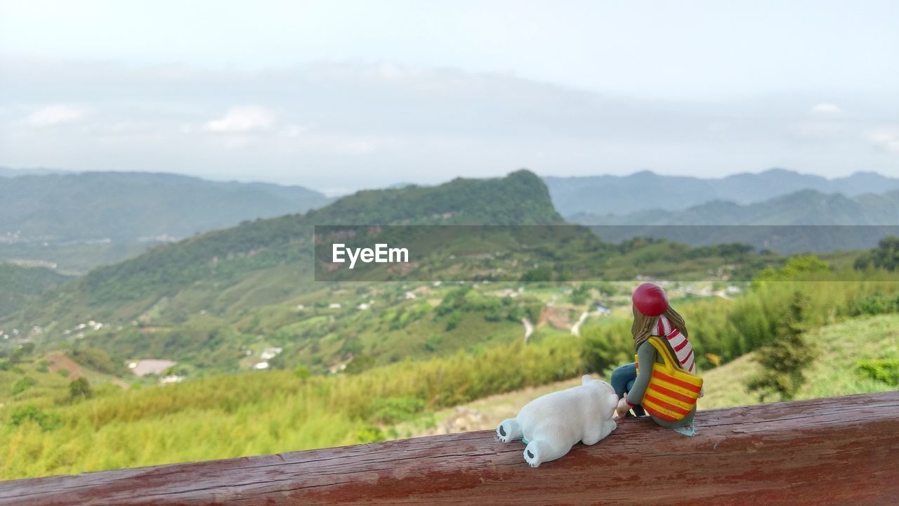 MAN ON LANDSCAPE AGAINST MOUNTAINS