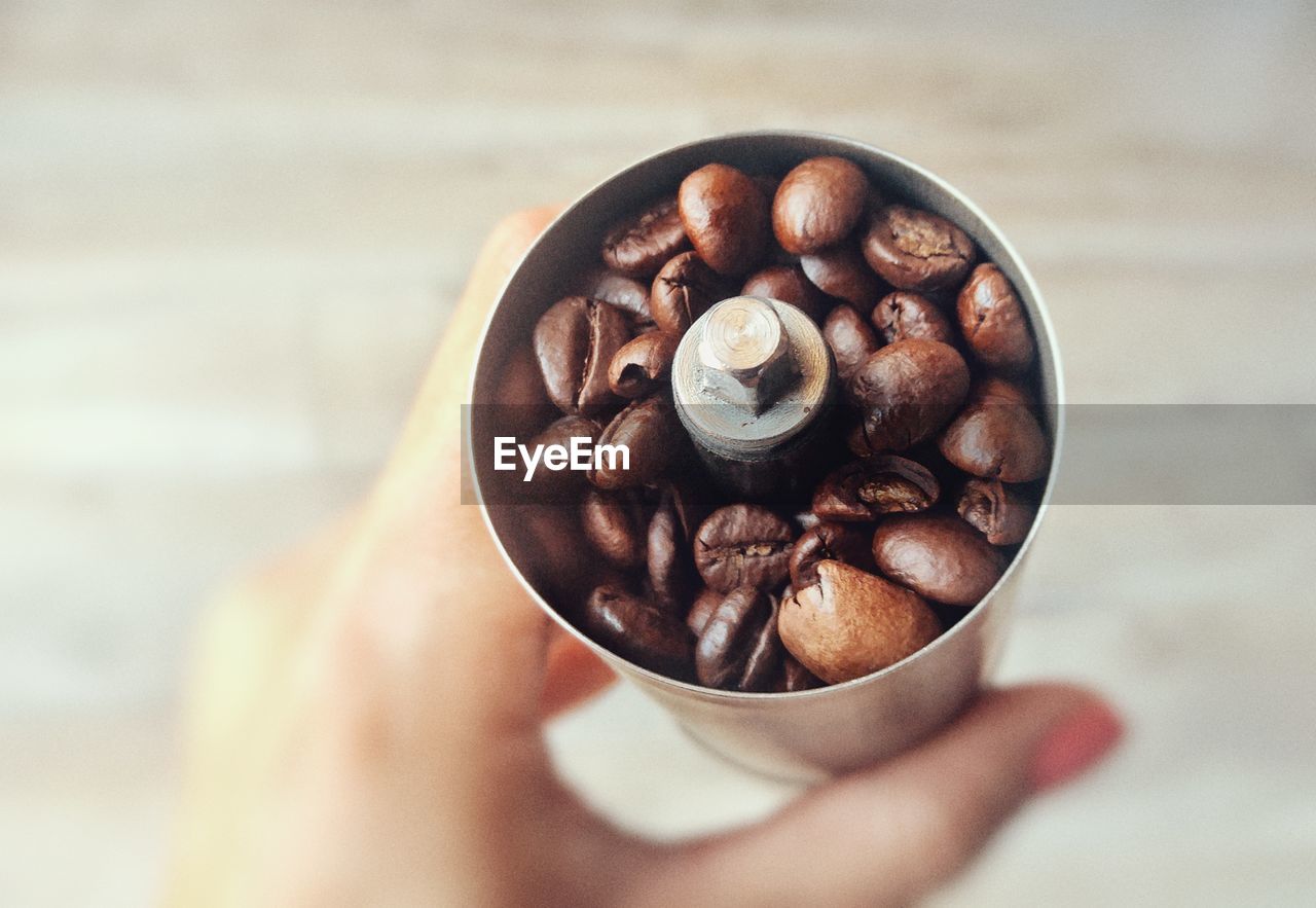 CLOSE-UP OF HAND HOLDING COFFEE