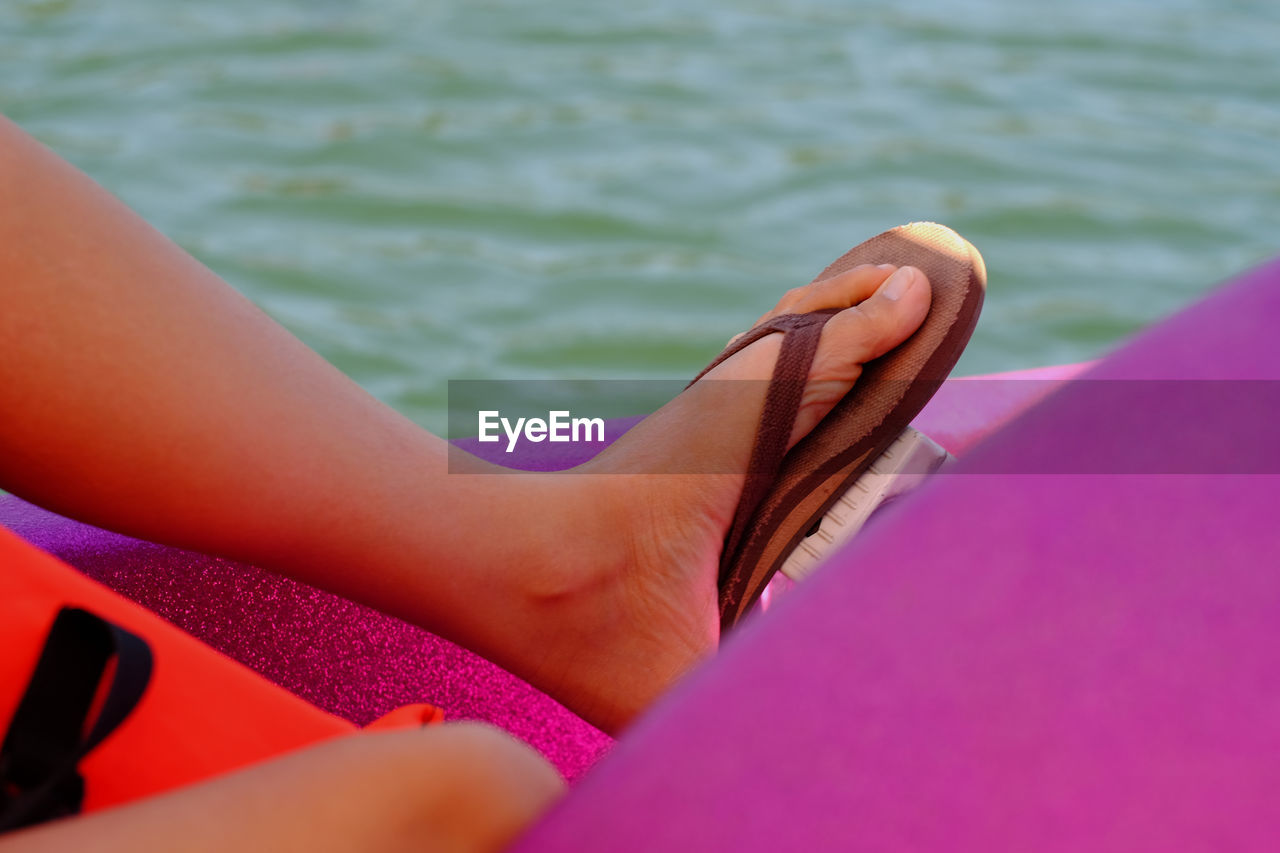 Low section of man in pedal boat on lake