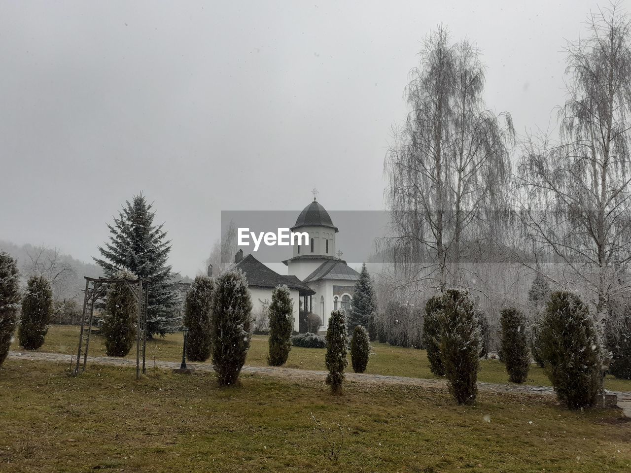 tree, plant, architecture, sky, nature, built structure, religion, building, building exterior, place of worship, no people, grass, winter, belief, rural area, travel destinations, spirituality, history, landscape, the past, land, day, environment, outdoors, snow, field, house, fog, tranquility, tourism