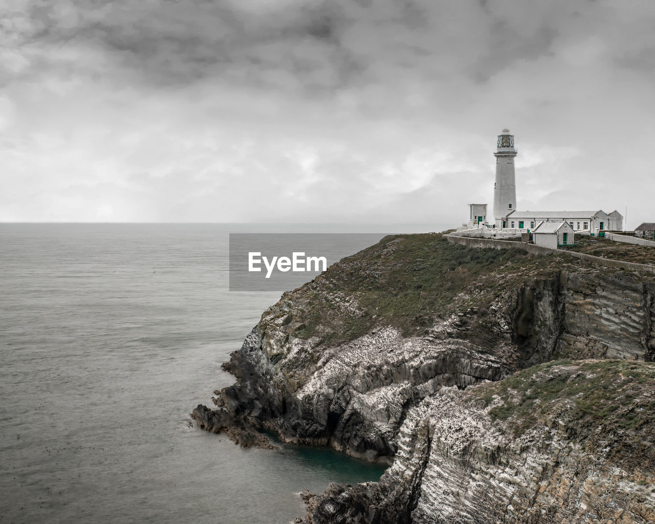 Lighthouse by sea against sky