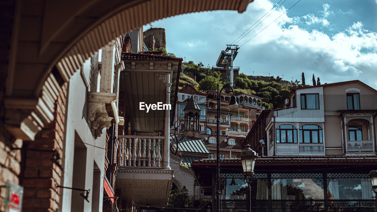 LOW ANGLE VIEW OF BUILDINGS AGAINST CLOUDY SKY