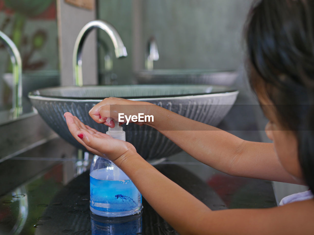 Girl washing hands in bathroom