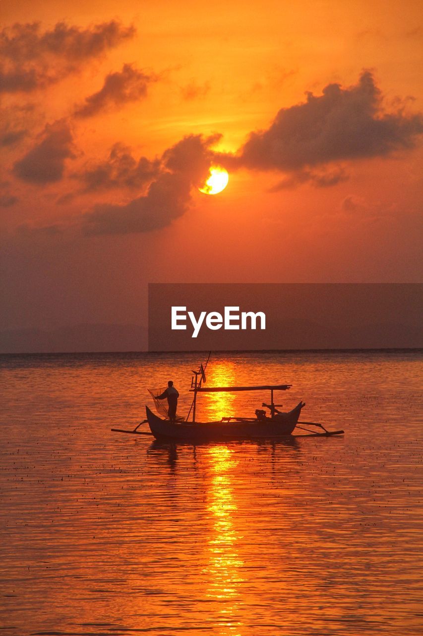 A fisherman working in the morning sunrise