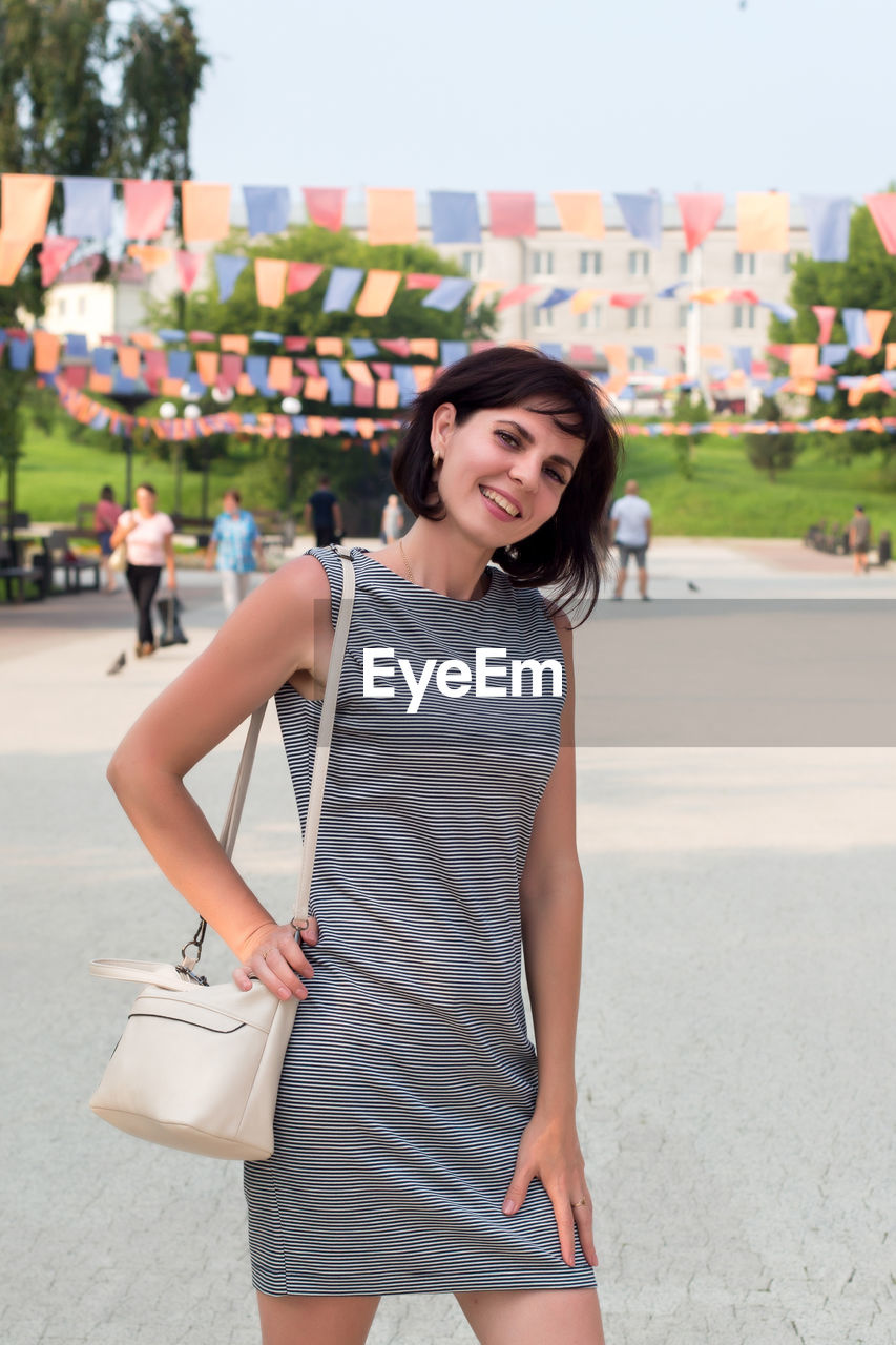 Happy young woman on a city holiday. standing in a busy city square. person