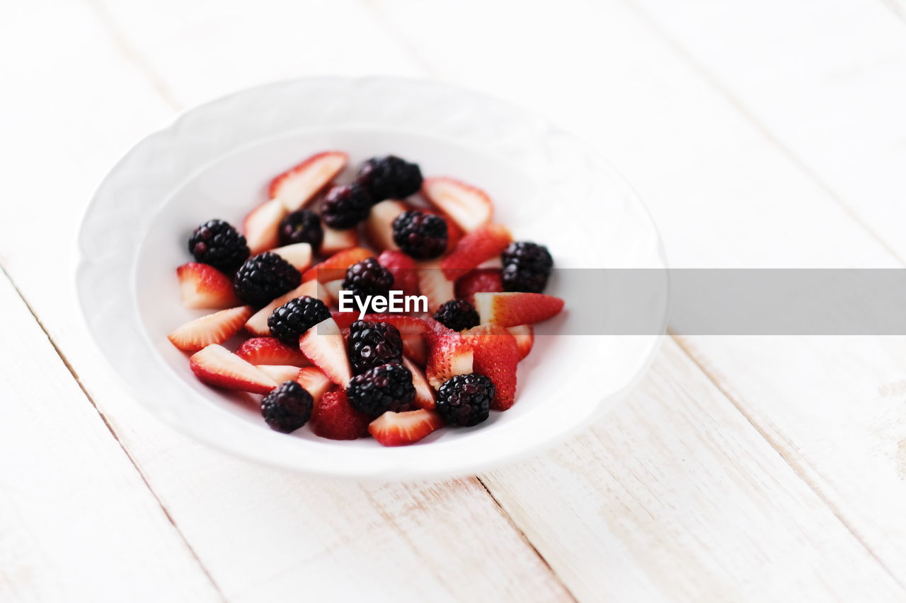 Close-up of berry fruits in bowl on table