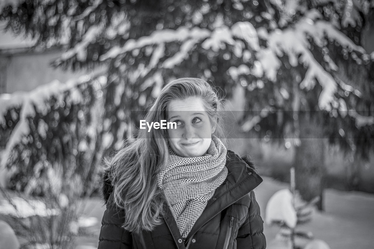 Smiling young woman looking away during winter