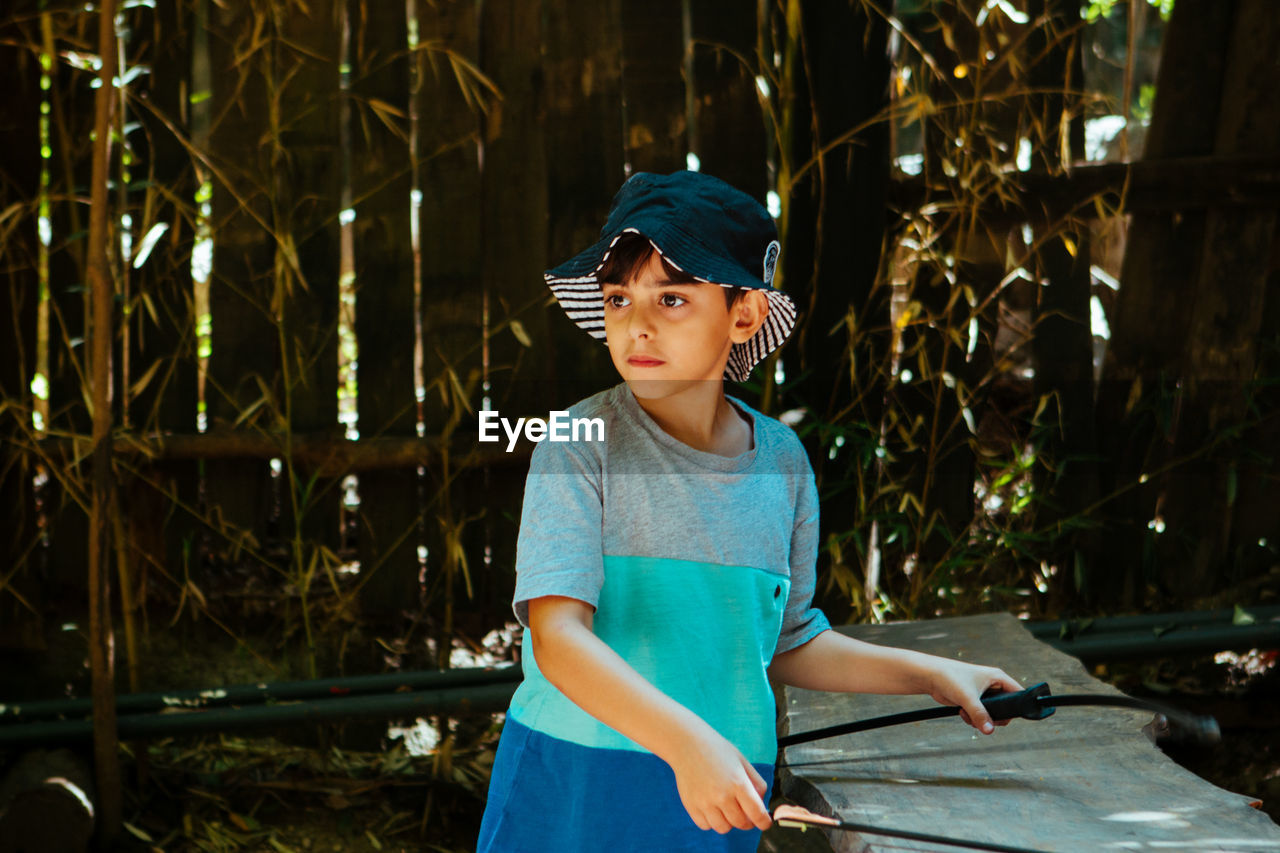 Boy looking away while standing outdoors