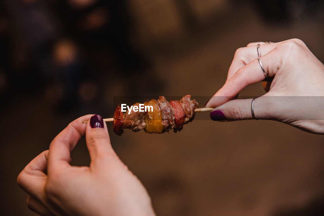 CLOSE-UP OF PERSON HAND HOLDING ICE CREAM