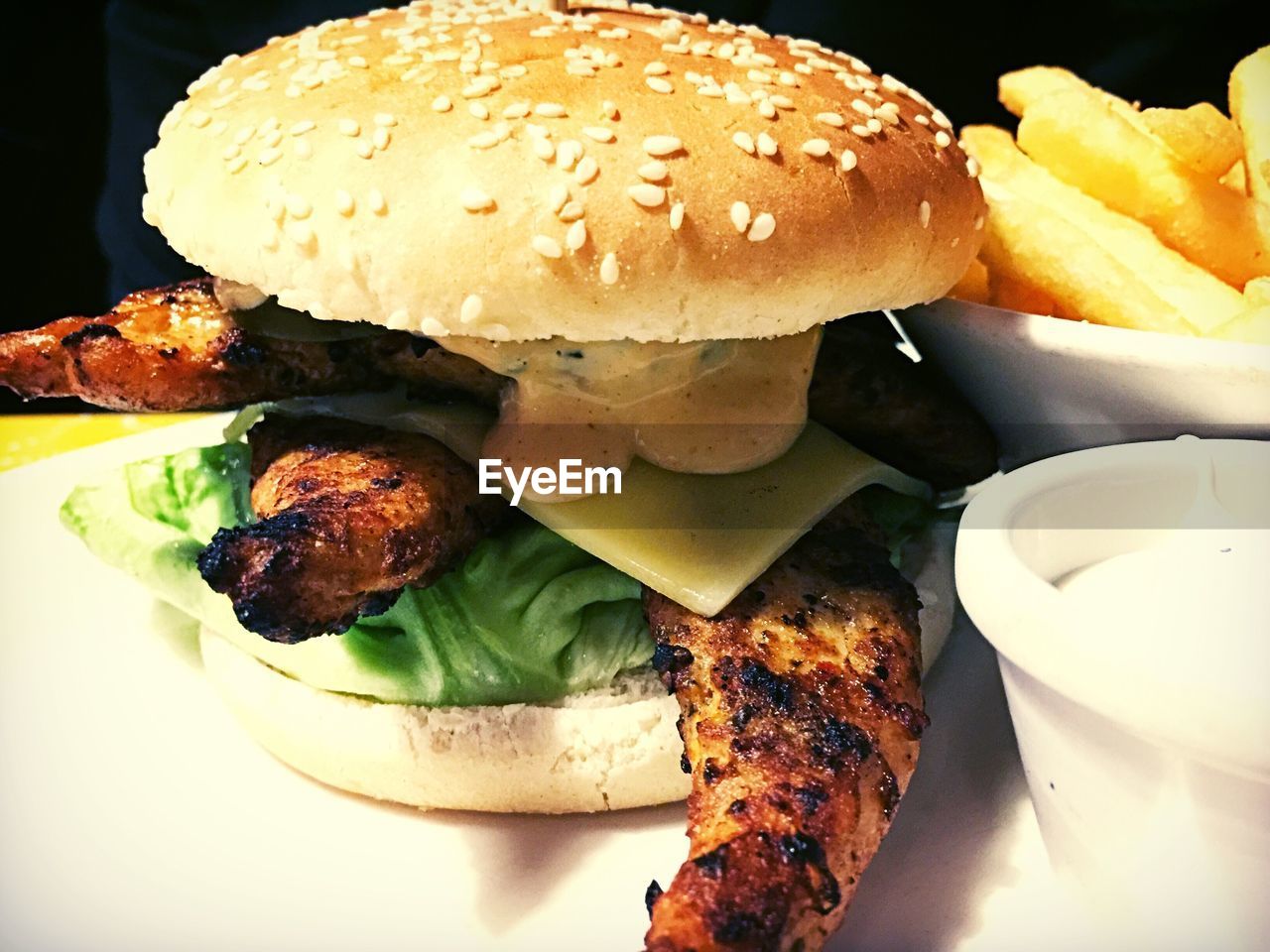 Close-up of chicken burger and french fries on table
