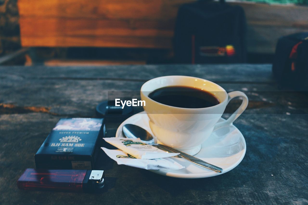 COFFEE CUP ON TABLE AT CAFE