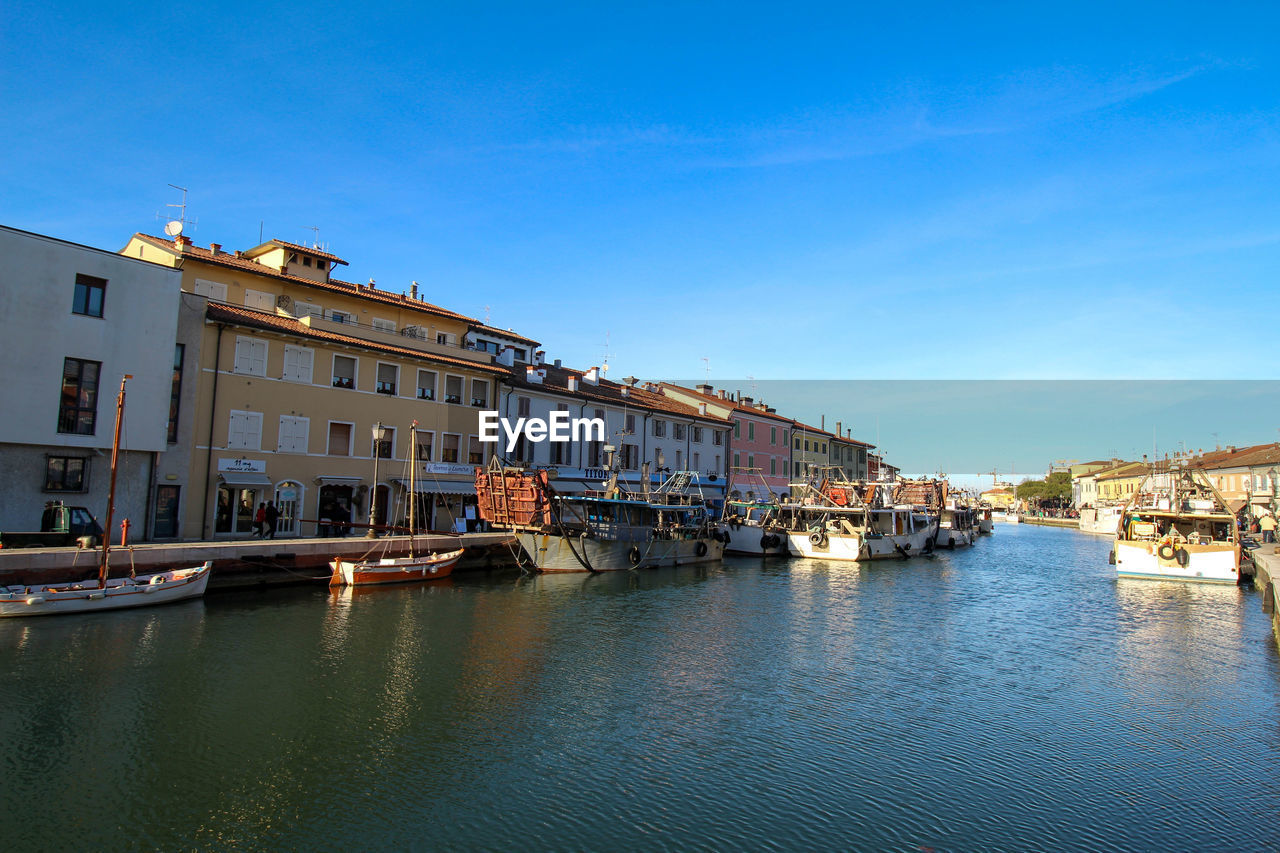 Boats moored in leonardo da vinci canal by buildings in city against sky