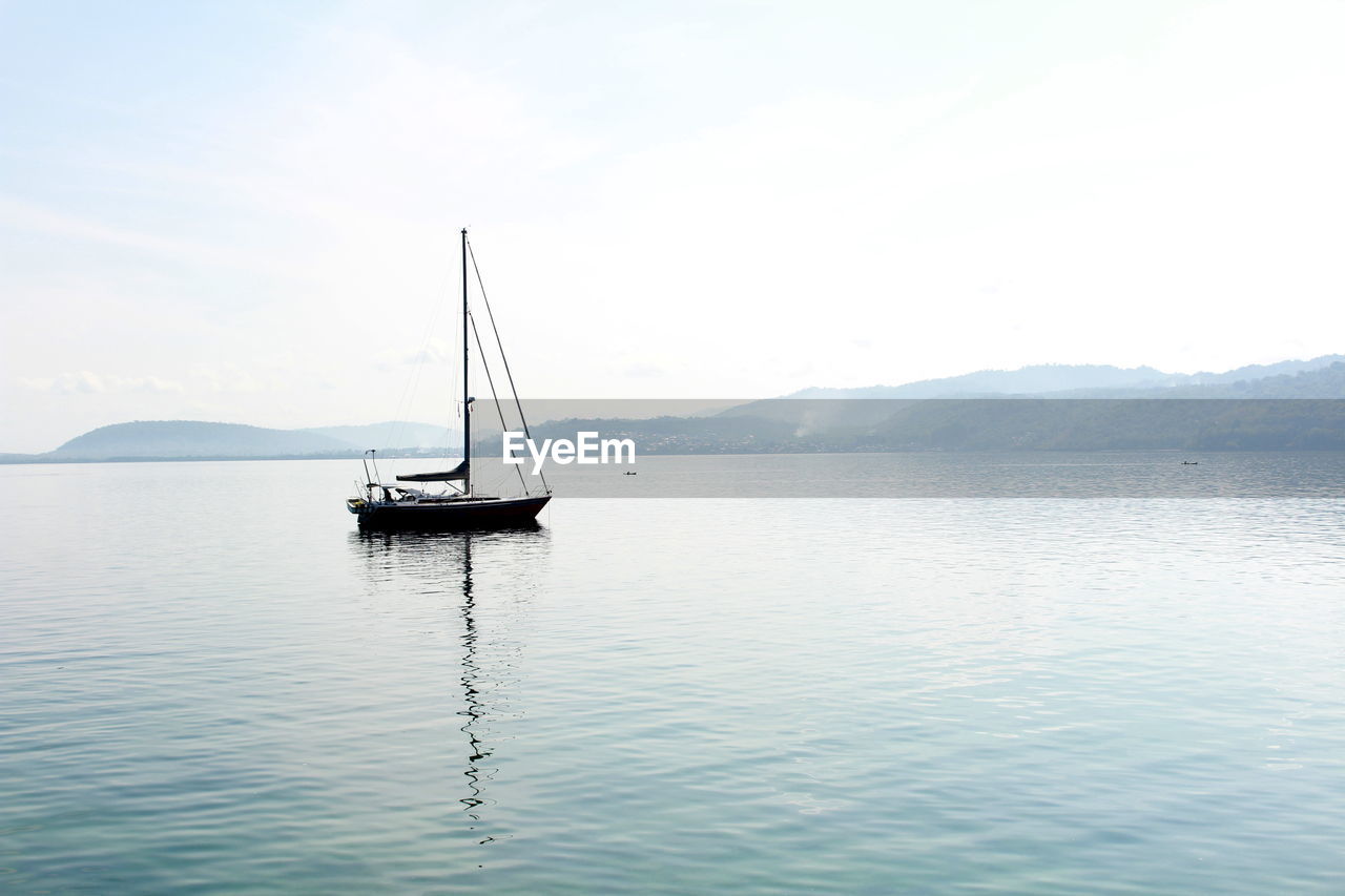 Sailboat sailing on sea against sky