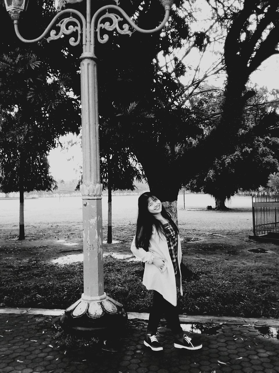 WOMAN STANDING ON FOOTPATH BY TREE