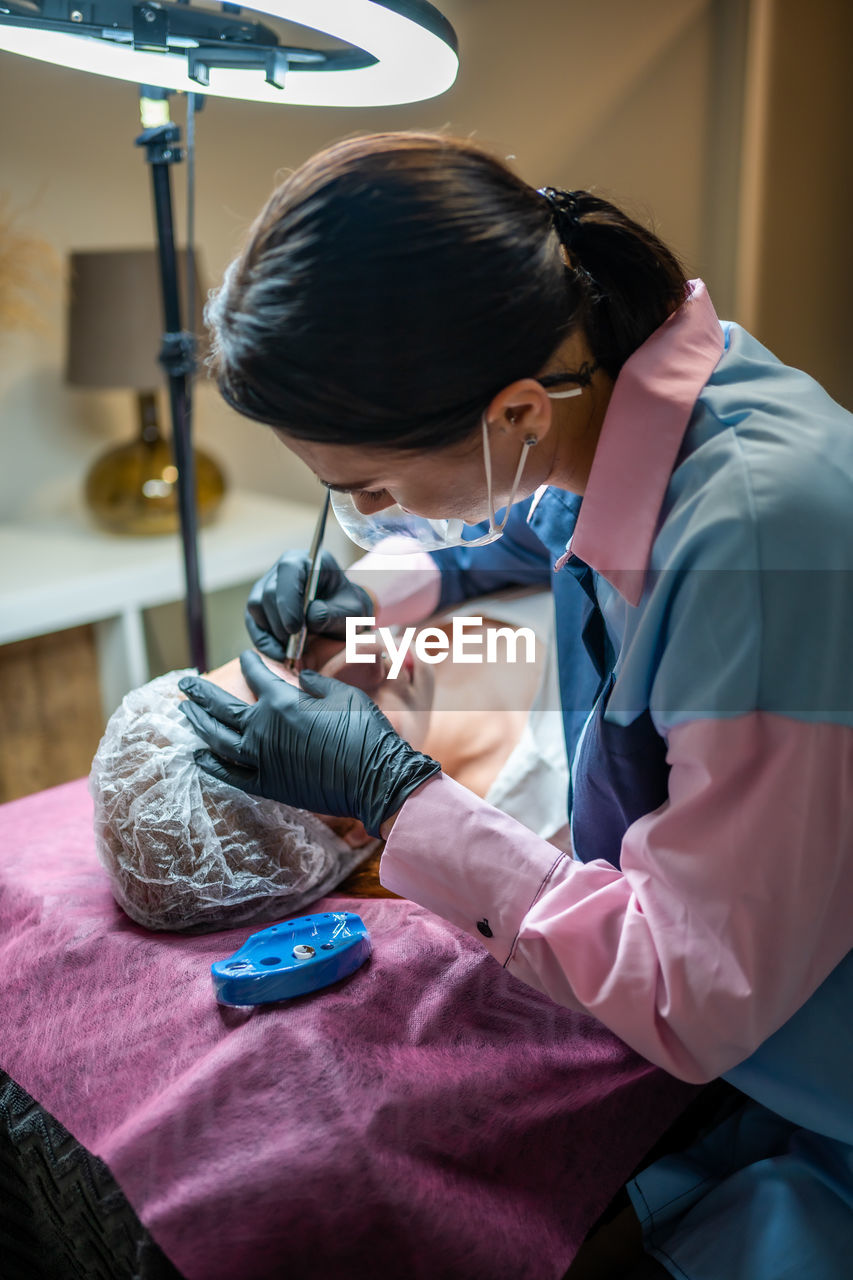 side view of doctor examining patient at home