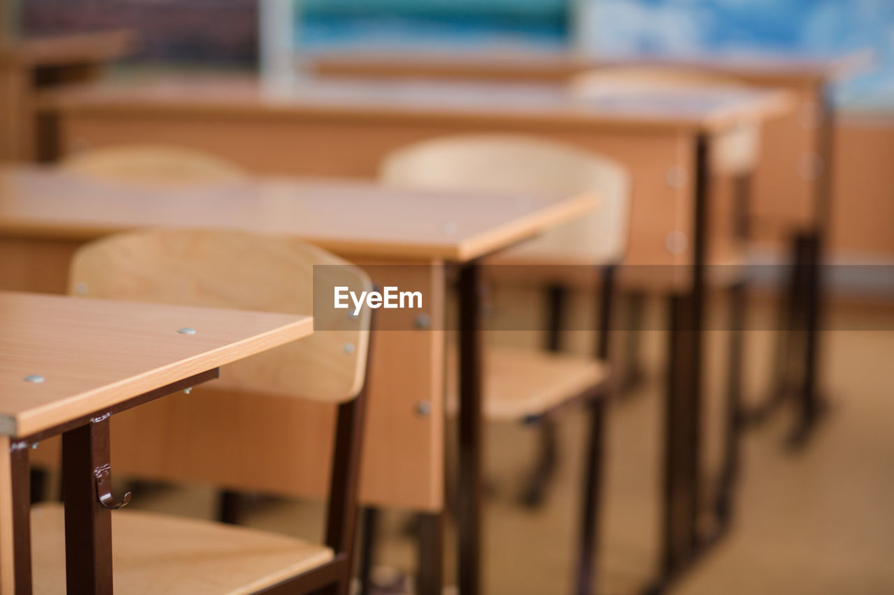 EMPTY CHAIRS AND TABLES IN BACKGROUND