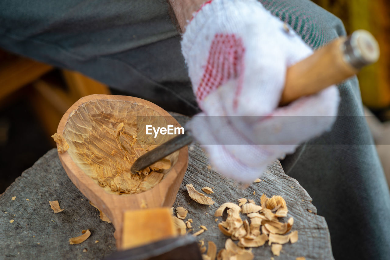 Midsection of man carving wood