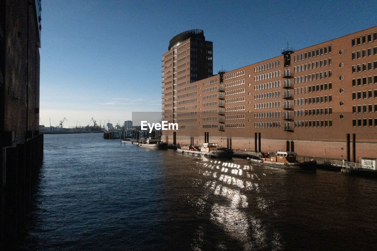 River by buildings against sky in city