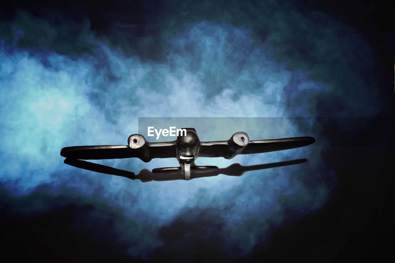 LOW ANGLE VIEW OF TELEPHONE AGAINST BLACK BACKGROUND