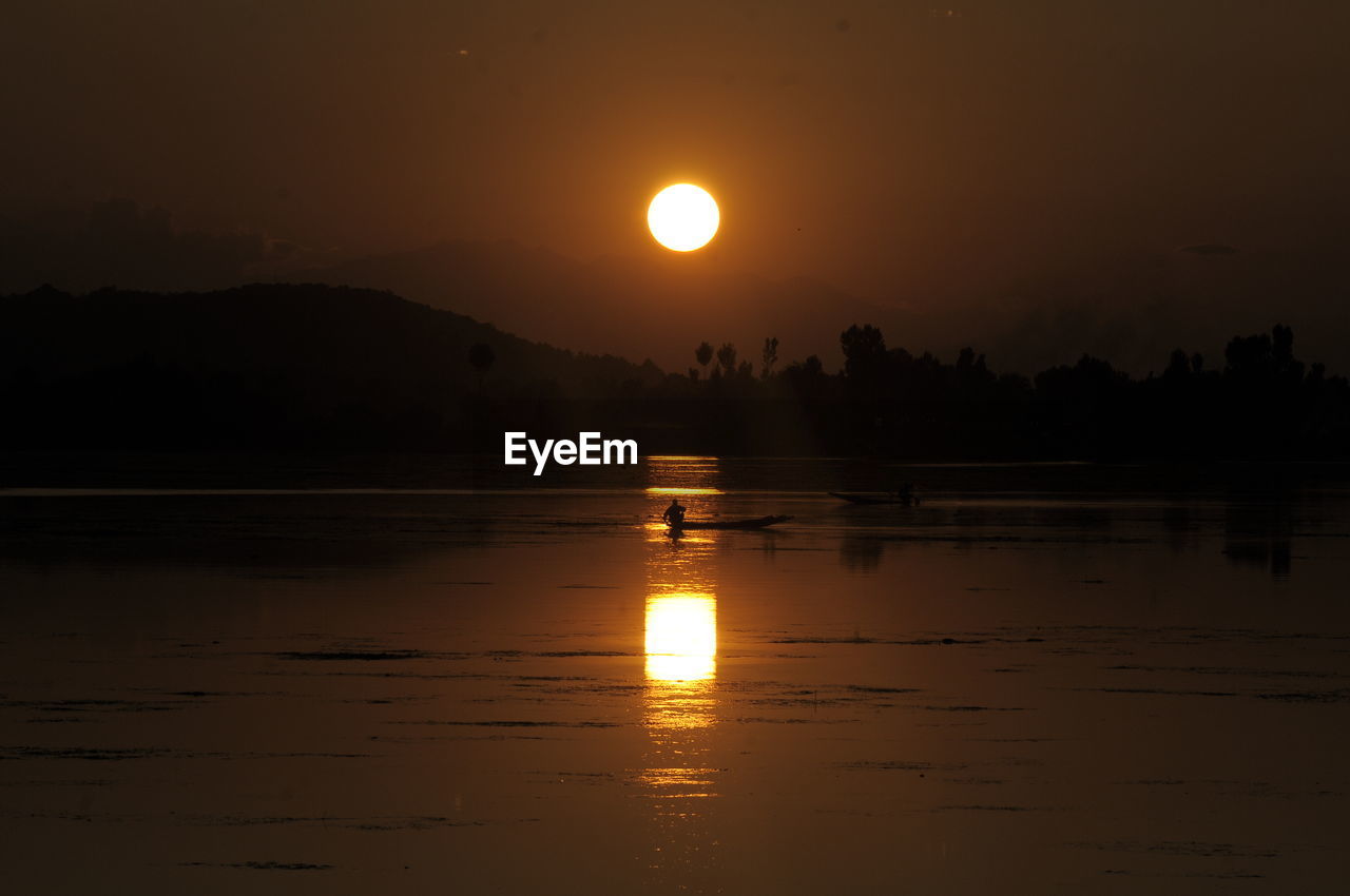 Scenic view of lake against sky during sunset