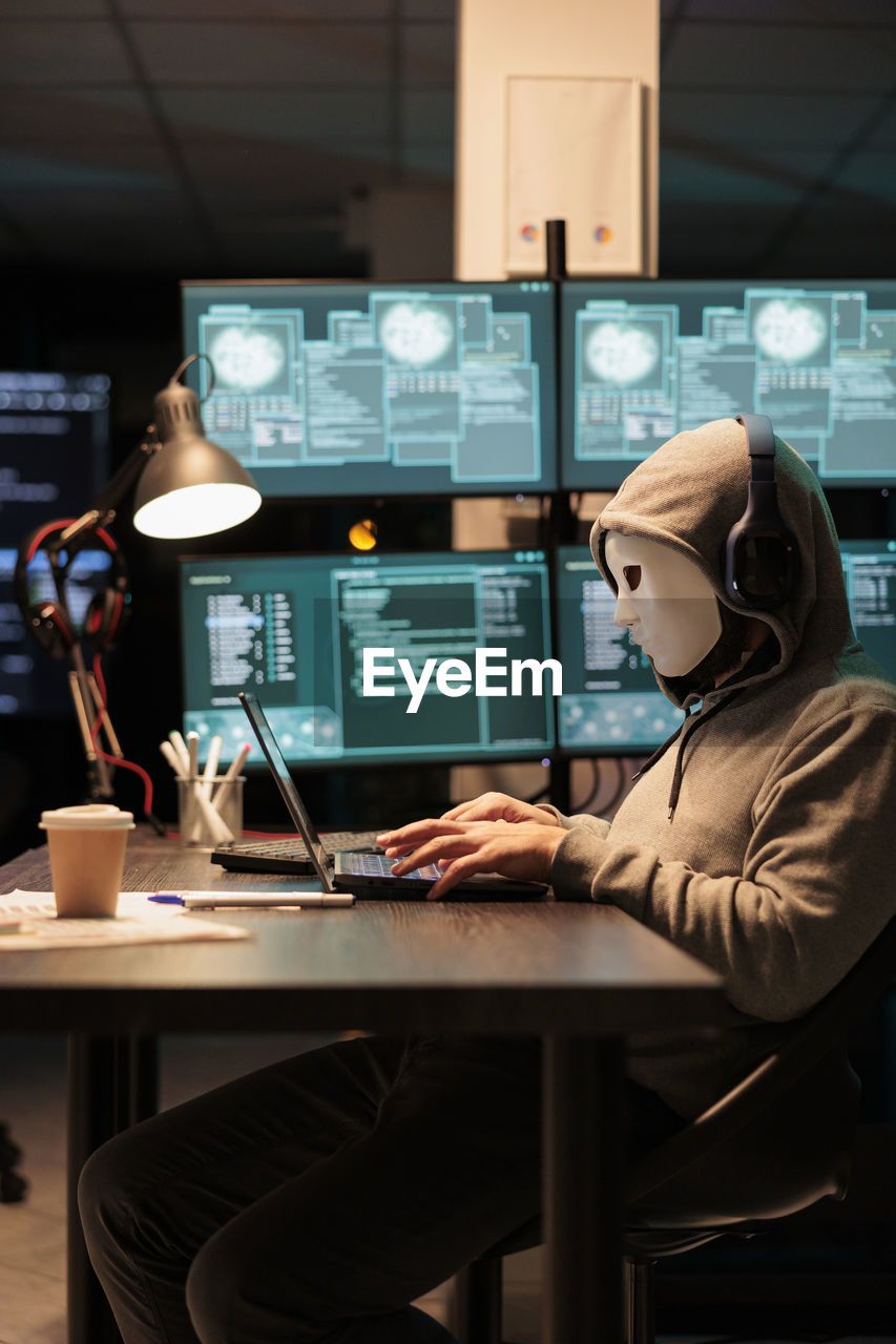 rear view of woman using laptop at table