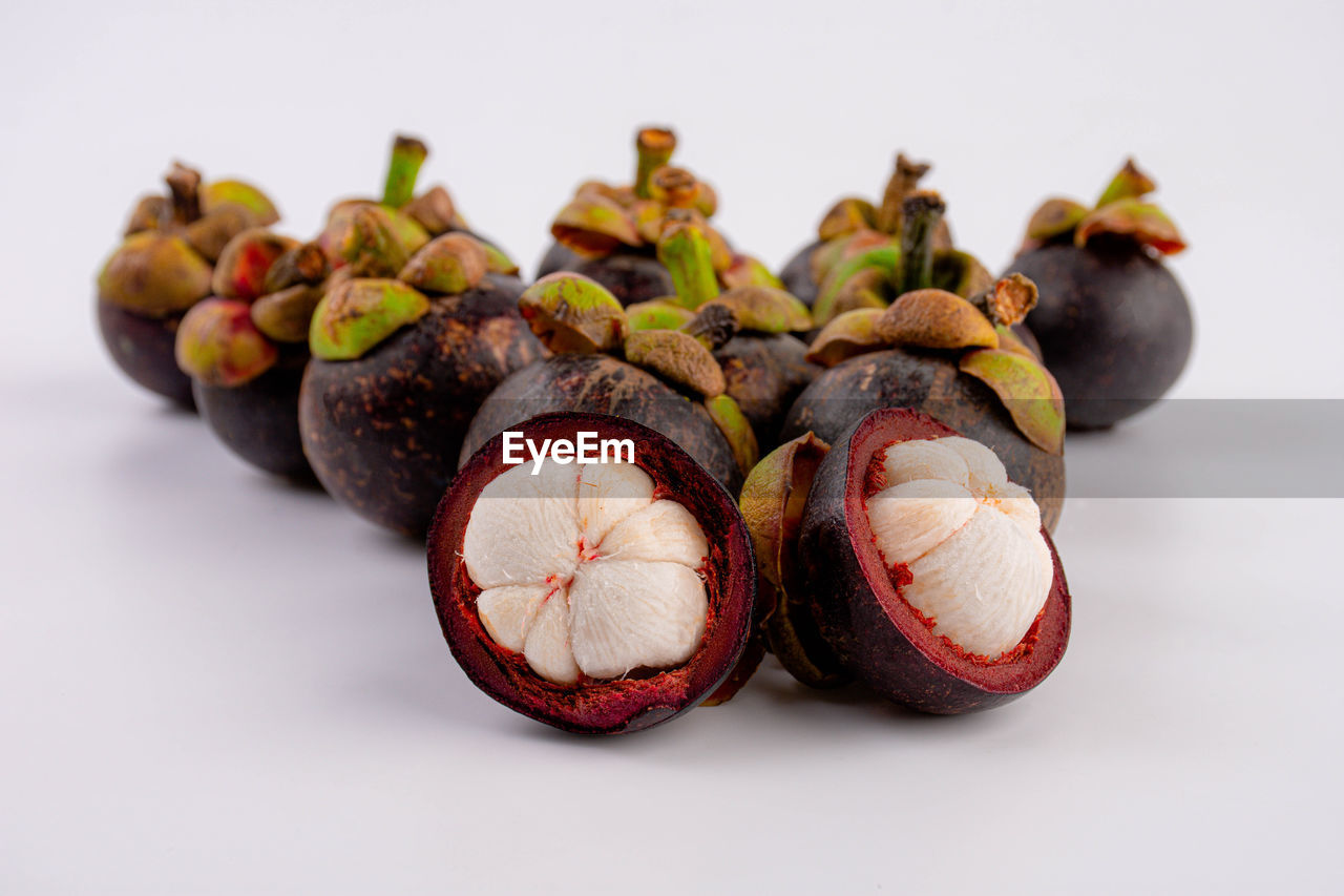 Queen of fruit in thailand. fresh mangosteen fruit and half mangosteen isolated on white background.