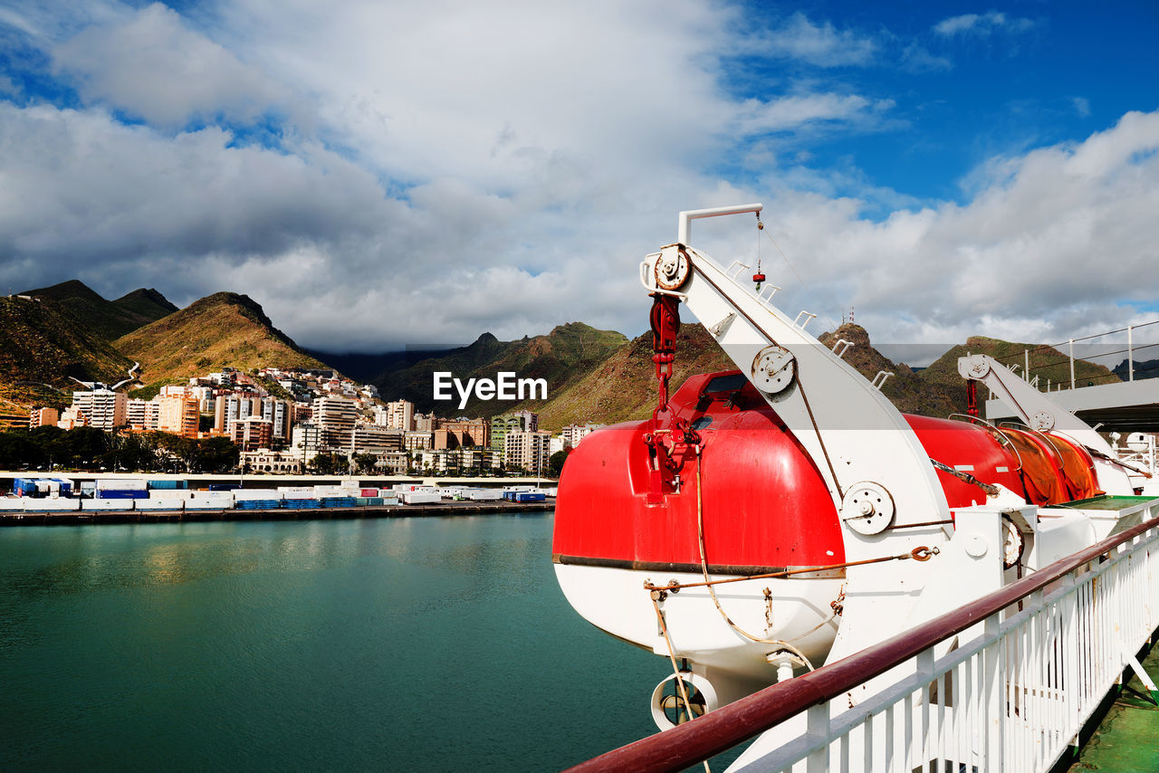 Lifeboat on cruise ship in sea against cloudy sky at canary islands