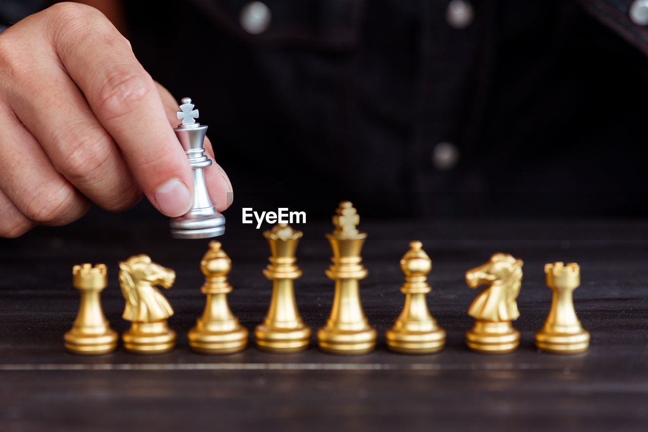 Cropped image of hand holding chess piece