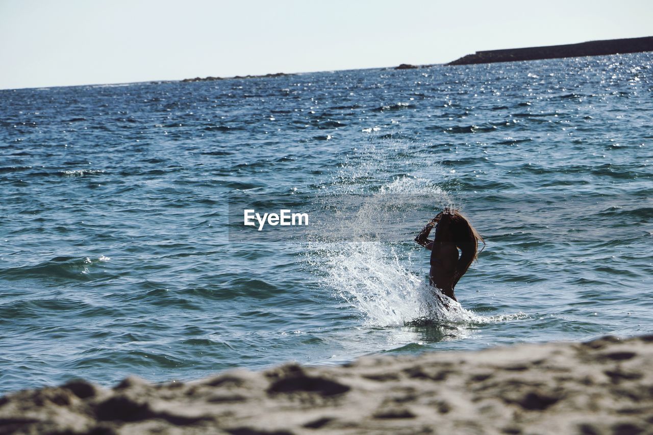 FULL LENGTH OF MAN SWIMMING IN SEA