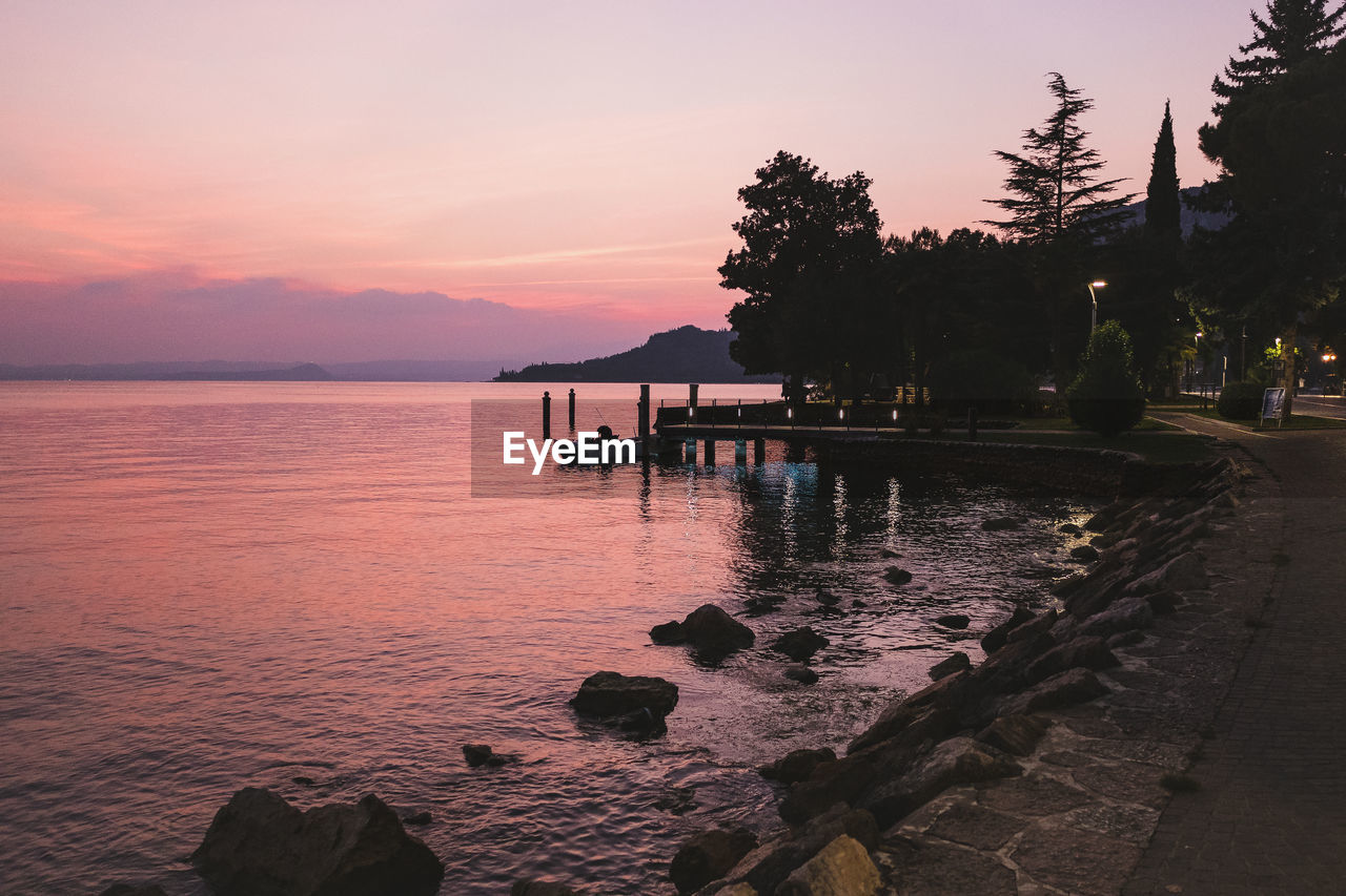 SCENIC VIEW OF SWIMMING POOL AGAINST SKY AT SUNSET