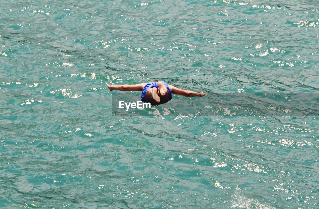 HIGH ANGLE VIEW OF GIRL SWIMMING IN SEA