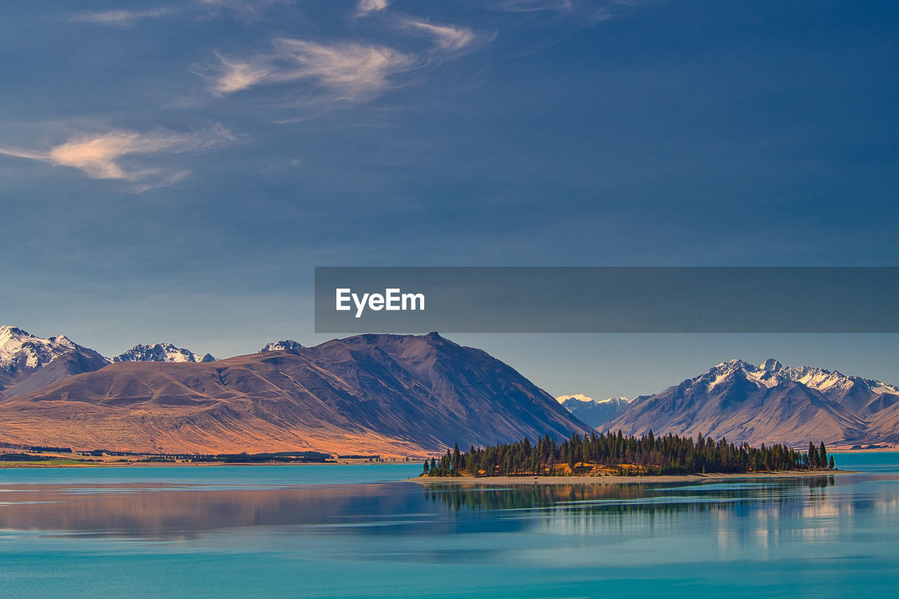 Scenic view of lake by mountains against sky