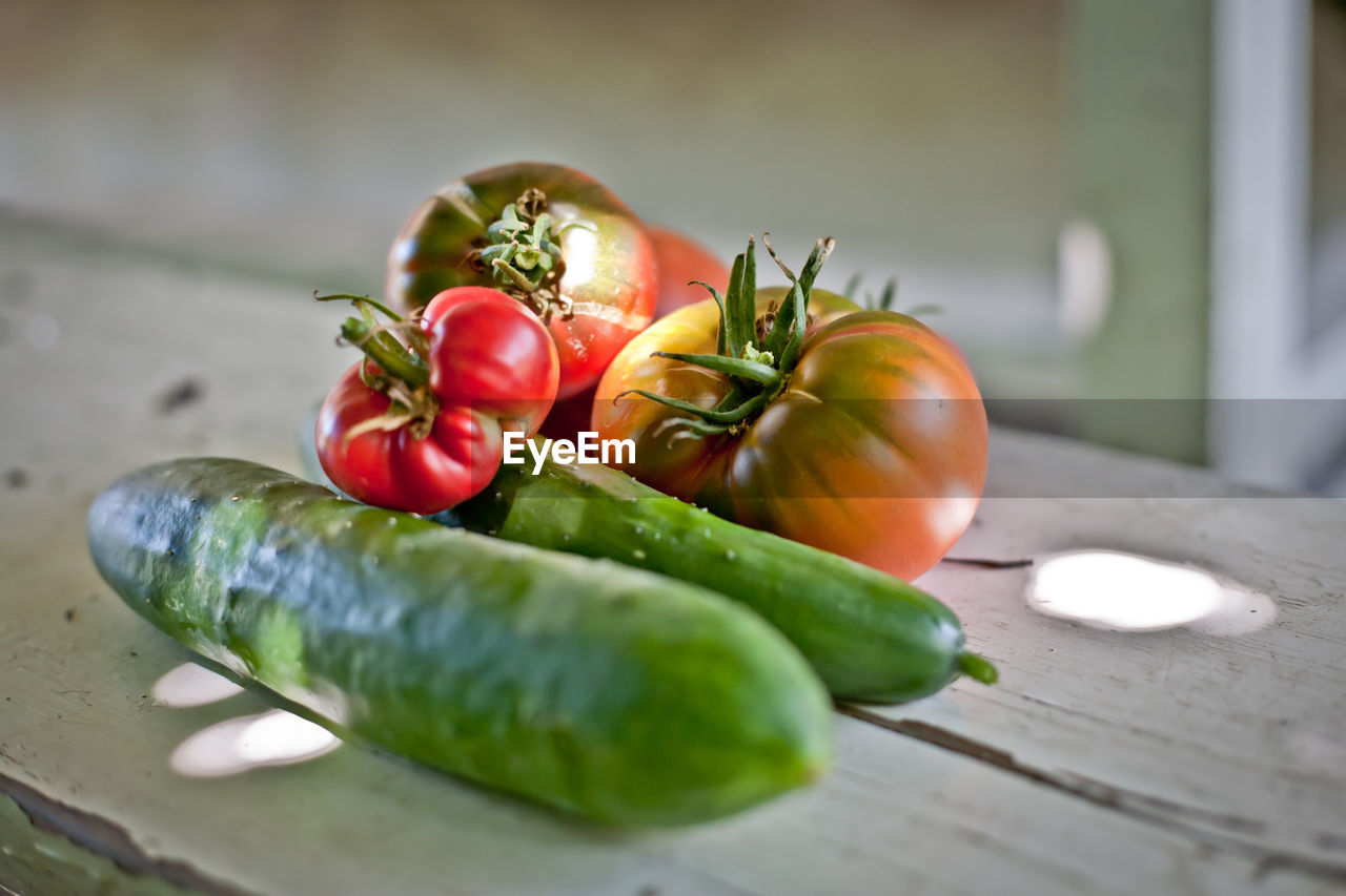 Close-up of tomatoes on table. fresh vegetables on old table, cucumbers and tomatoes still life shot