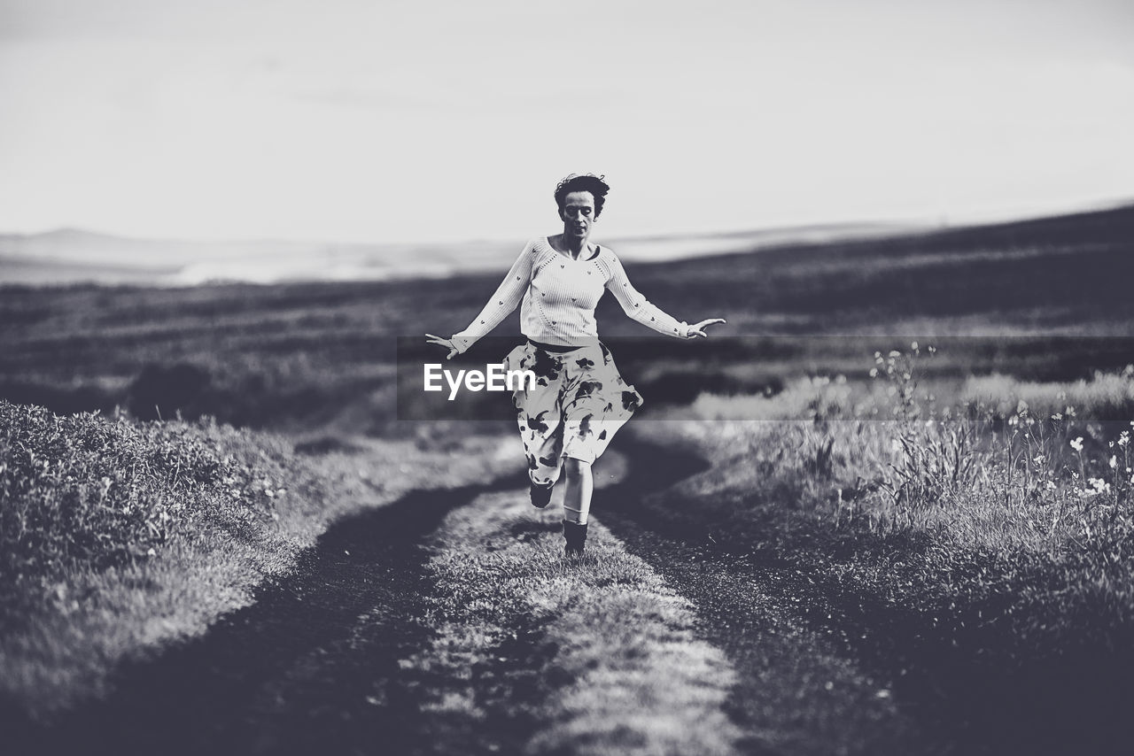 WOMAN WALKING ON FIELD