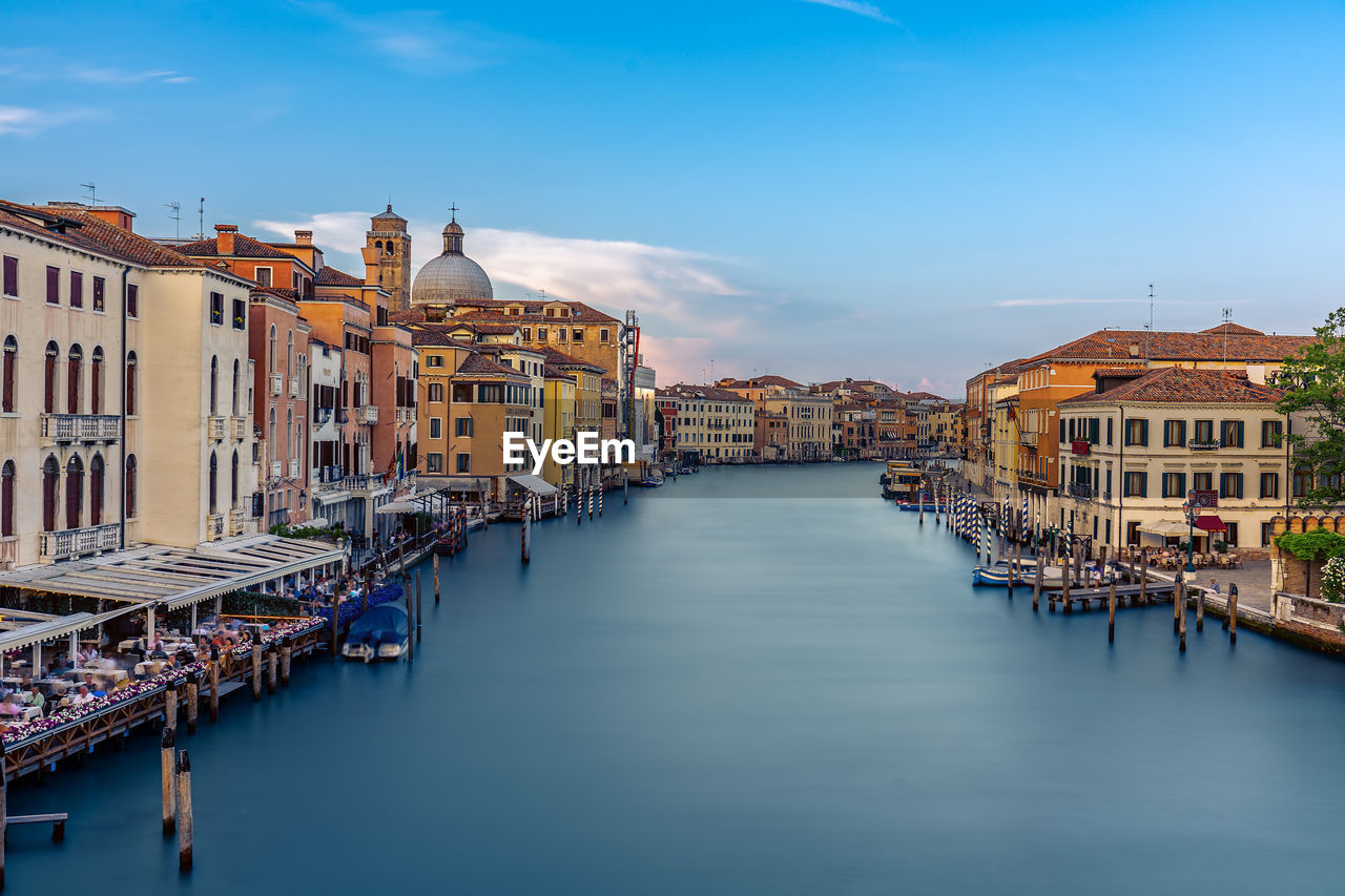 boats in river in city against sky