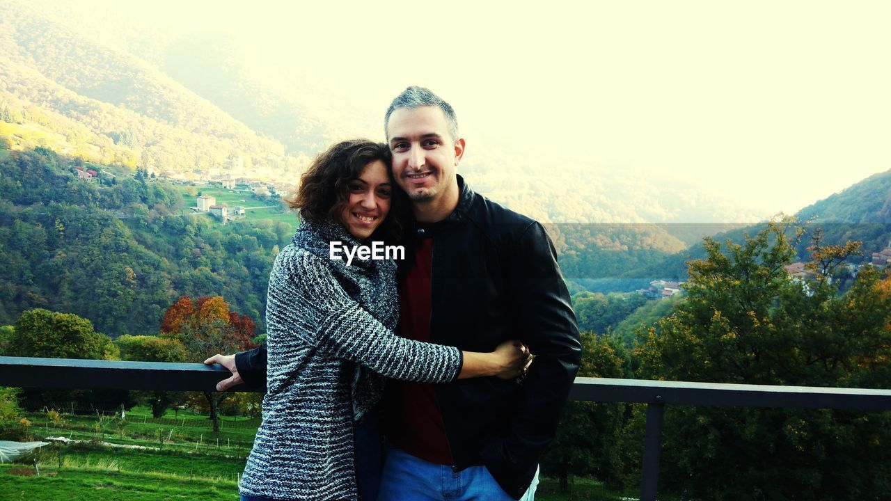 Portrait of couple at observation point against mountains