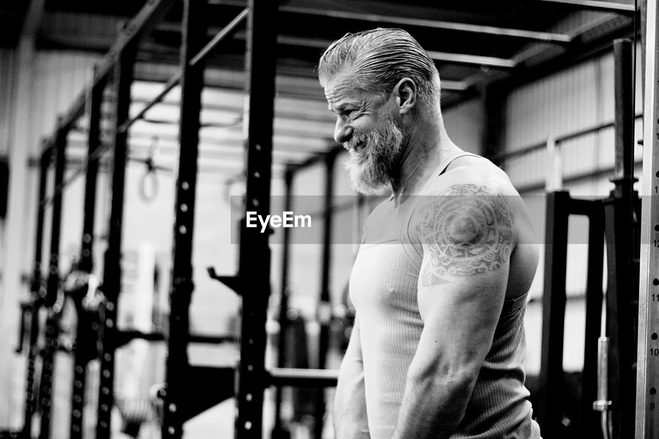 Side view of mature man standing in gym