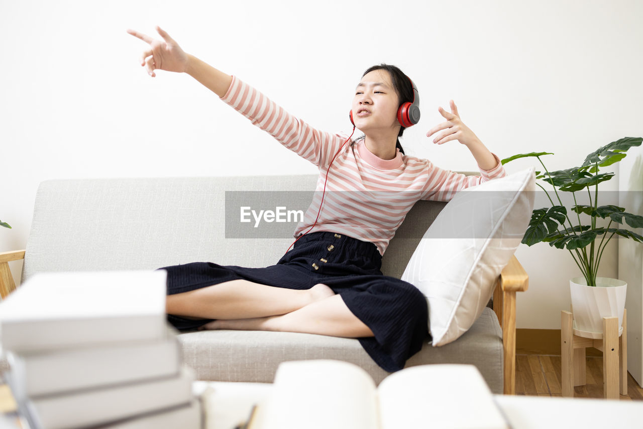 side view of woman sitting on sofa at home