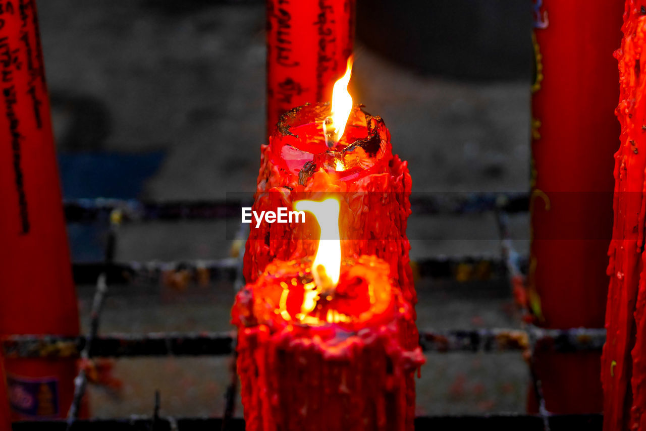CLOSE-UP OF LIT CANDLES IN FIRE