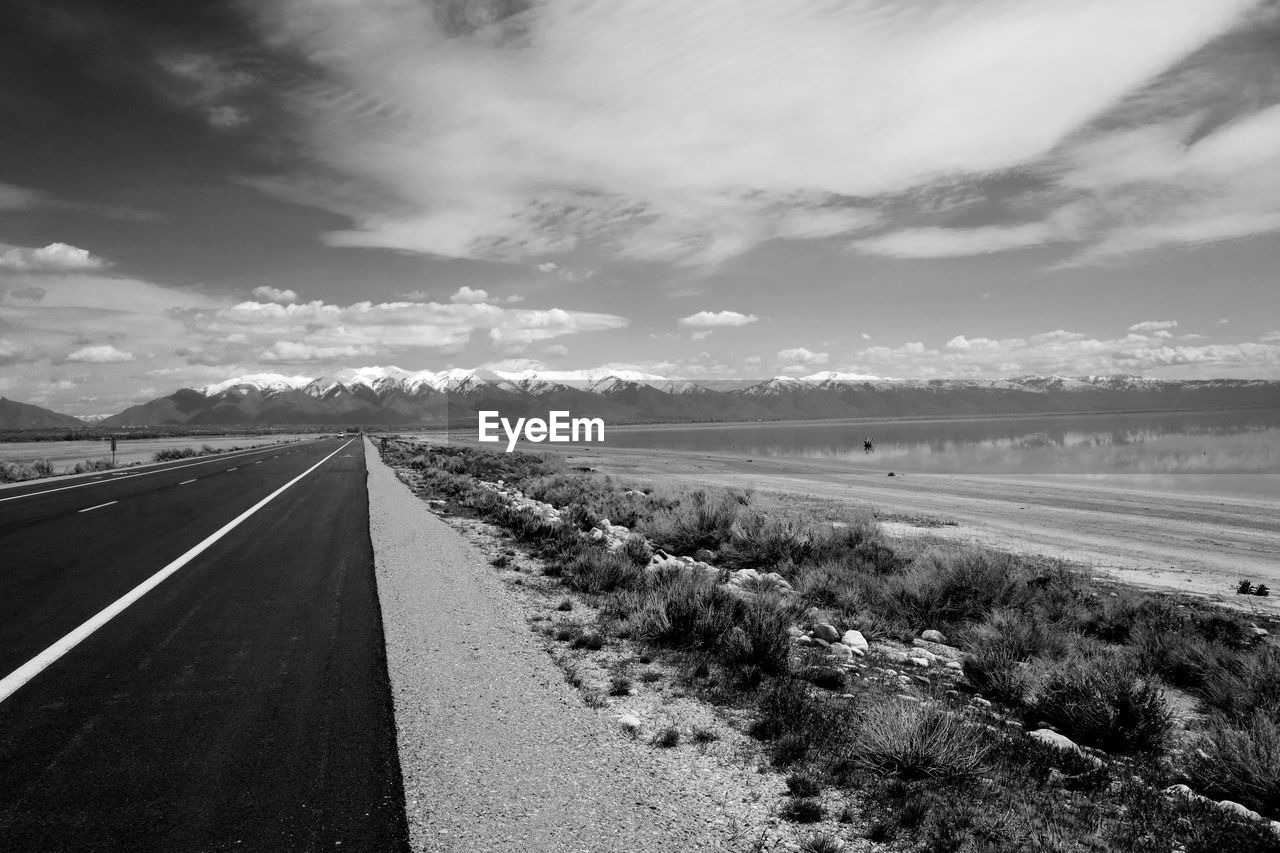 High angle view of empty road by river against sky