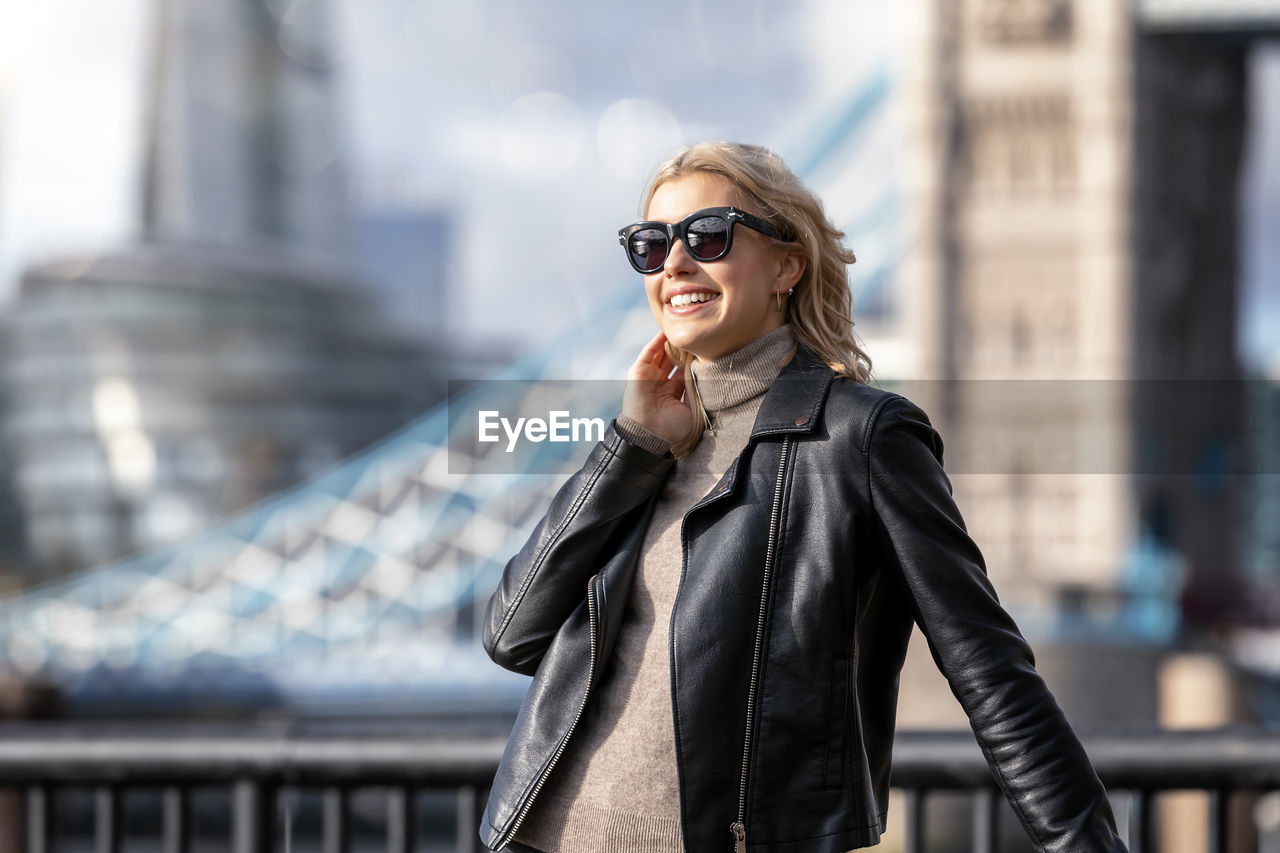 Young woman standing on bridge in city