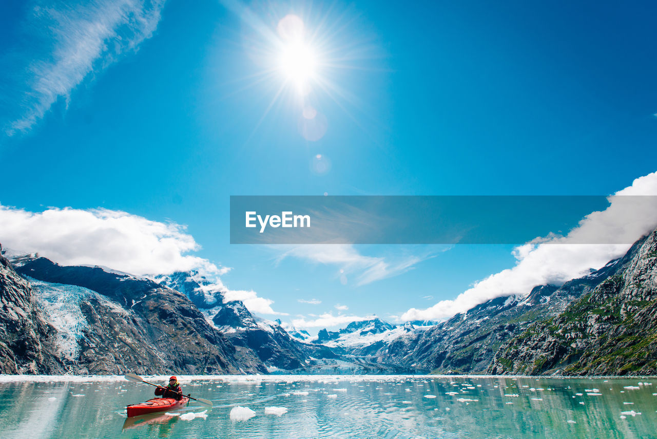 Woman kayaking in glacier bay national park with glacier in background