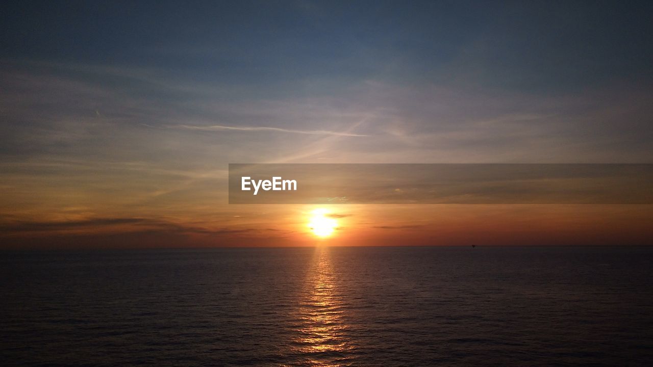 SCENIC VIEW OF SUNSET OVER SEA