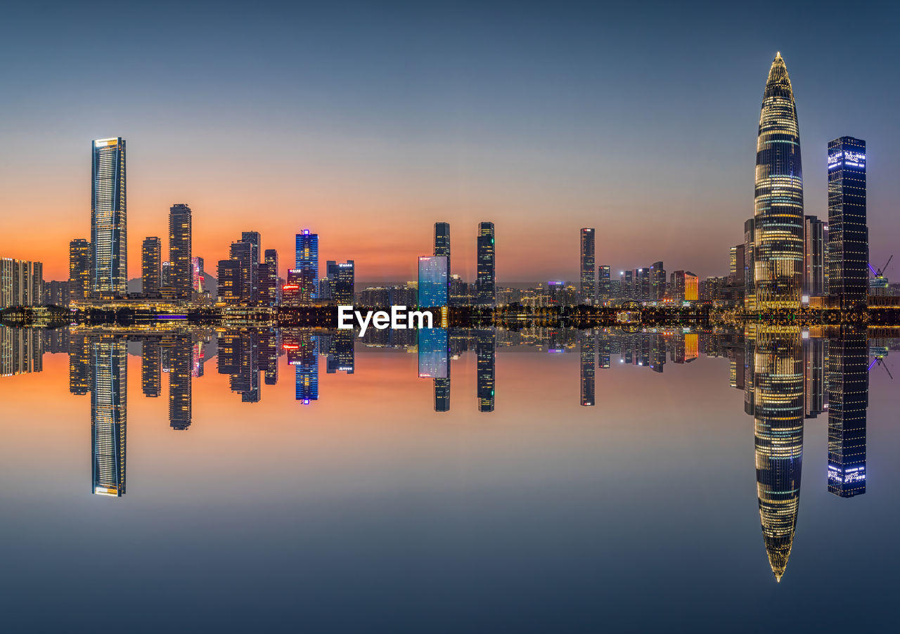 Illuminated buildings in city against sky