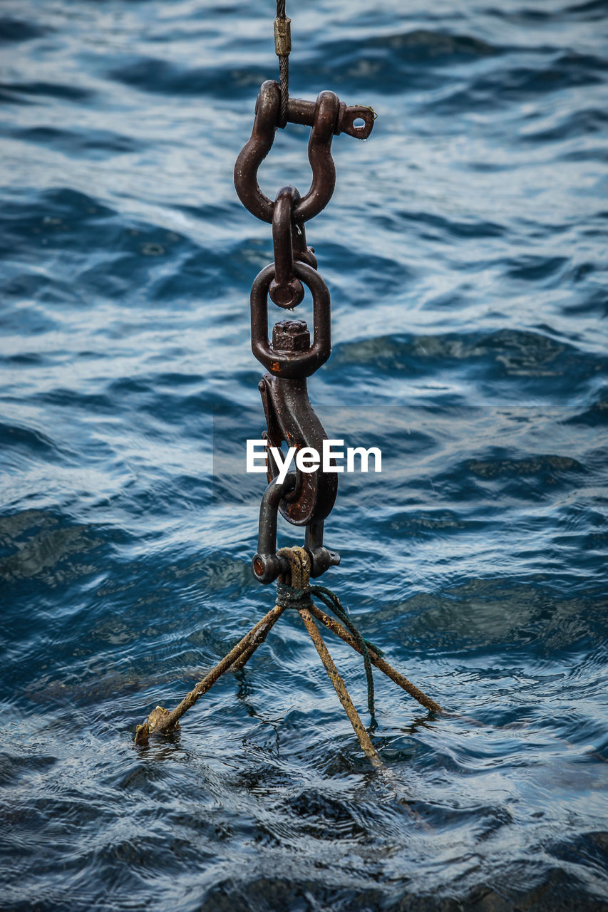 HIGH ANGLE VIEW OF CHAIN HANGING IN SEA