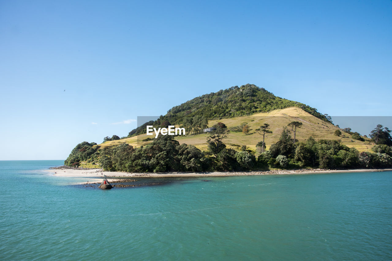 SCENIC VIEW OF SEA AND MOUNTAINS AGAINST CLEAR SKY